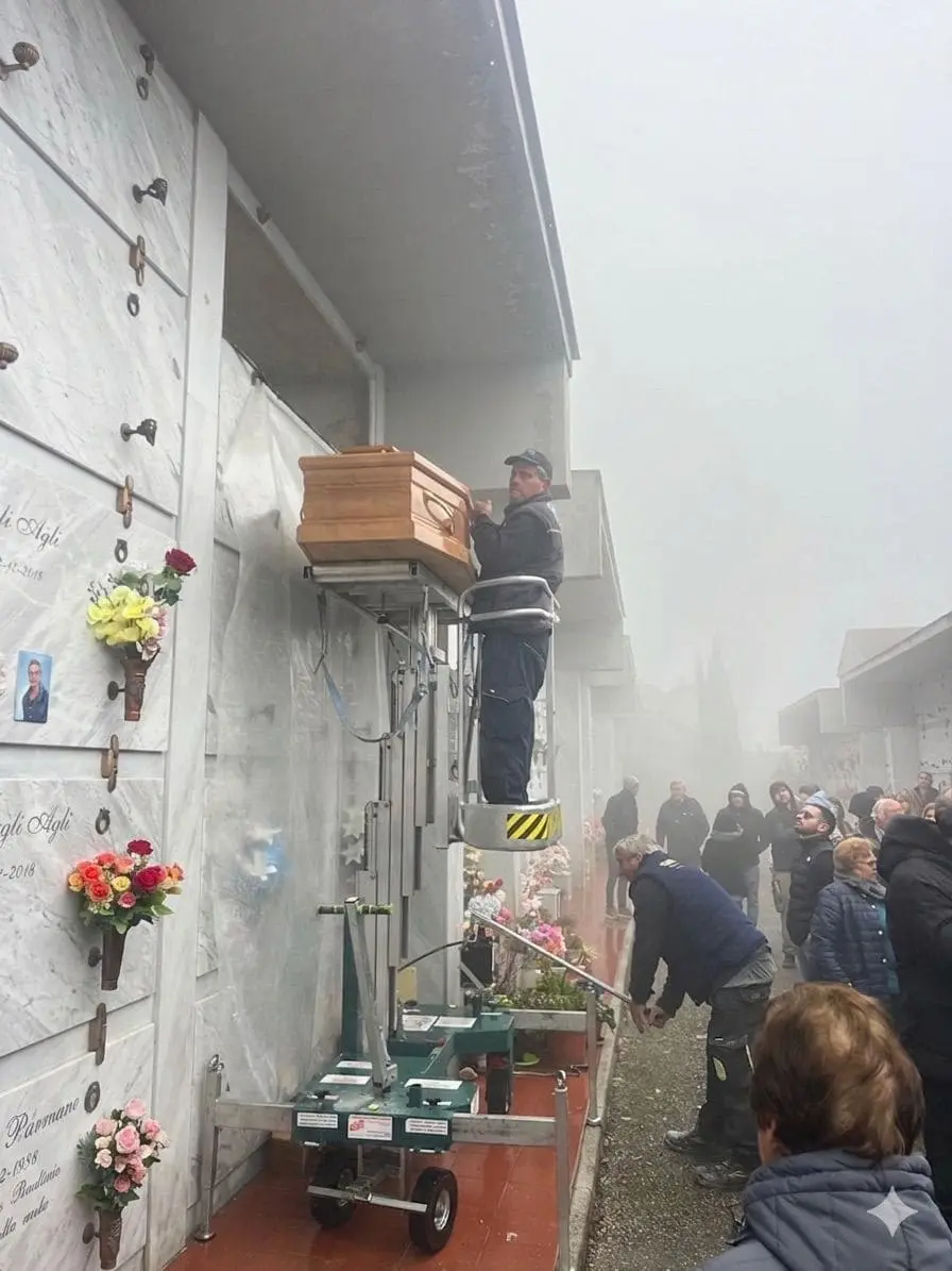 Macchinario elevato nella nebbia durante operazione cimiteriale